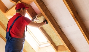 A picture of a work man insulating a loft.