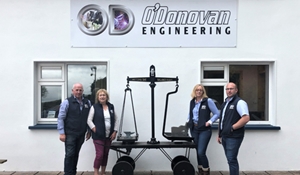 A picture with a group of employees standing outside, in front of a sign for O'Donovan Engineering.