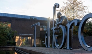 The Thomas Telford metal sculpture in town centre of Telford and Wrekin. Large individual metal words spelling out Telford, with a metal statue of Thomas Telford leaning against the "O".