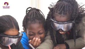 A picture of three pupils, laughing, while trying on a pair of alcohol goggles.