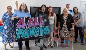 Young people stood with Cllr Shirley Reynolds holding "4 All Foundation" sign