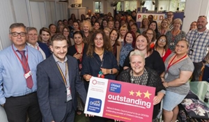 Cllr Shirley Reynolds with Children's staff and 'Outstanding' OFSTED sign