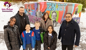Councillor Raj Mehta with staff and pupils from Hadley Learning Community at the unveiling of the sporting stars mural.