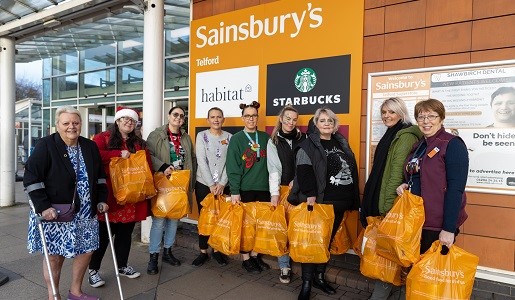 A group of people collecting food hampers from Sainsbury's