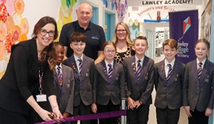 A group of staff and pupils cutting the ribbon at the official opening of the expanded Lawley Village Academy
