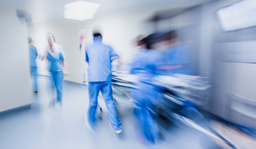 A blurred image of hospital staff pushing a trolley