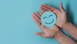 Hands holding a blue smiley face