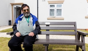 Man sits on recycled assistive technology bench