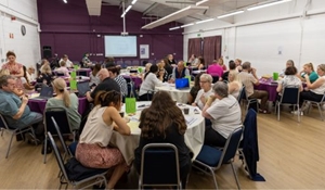 People sat at tables discussing at the Co-Production conference