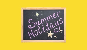 Summer holidays written in chalk on a chalkboard against a yellow background