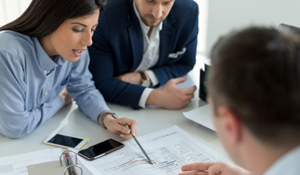 Business meeting with three professionals discussing plans at a table