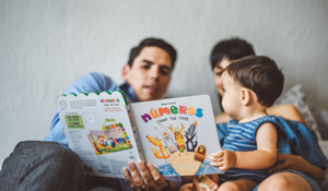 A father reading a book with his young child