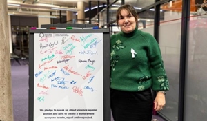 Cllr Kelly Middleton stands next to White Ribbon pledge signed board