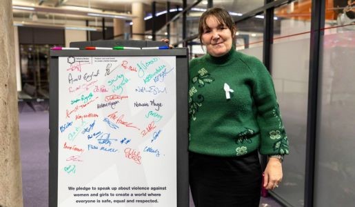 Cllr Kelly Middleton stands next to White Ribbon pledge signed board