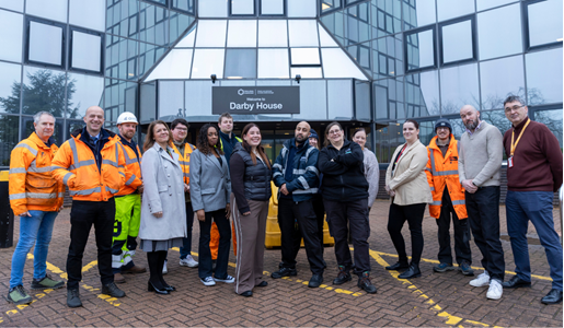 Members of Council staff standing in front of Darby House and smiling