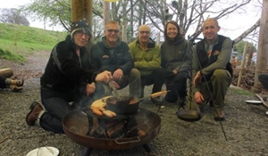 A group of people around a firepit at Arthog Wales