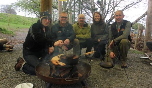 A group of people around a firepit at Arthog Wales