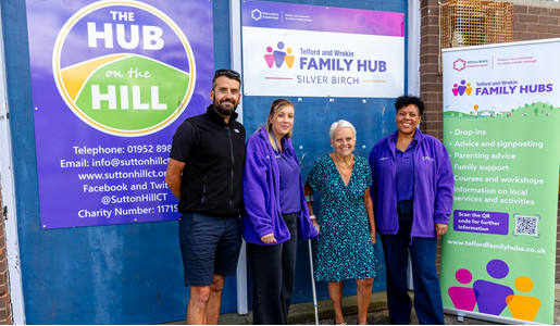 Four people standing in front of Telford and Wrekin Family Hub signage, including a man, two women in purple, and a woman.