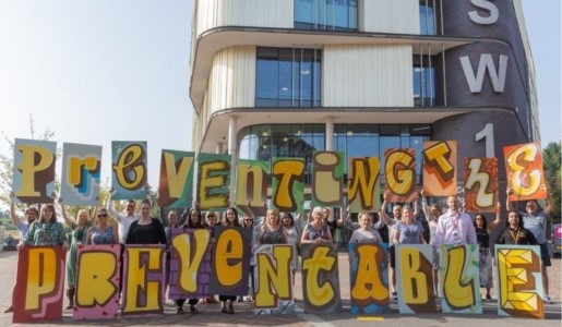 People hold up signs for WSPD that read 'Preventing the Preventable'