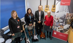 Music service opens in new home, group photo in music room with instruments on display
