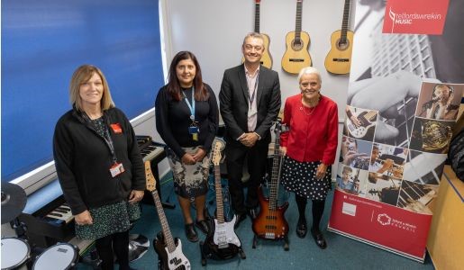 Music service opens in new home, group photo in music room with instruments on display